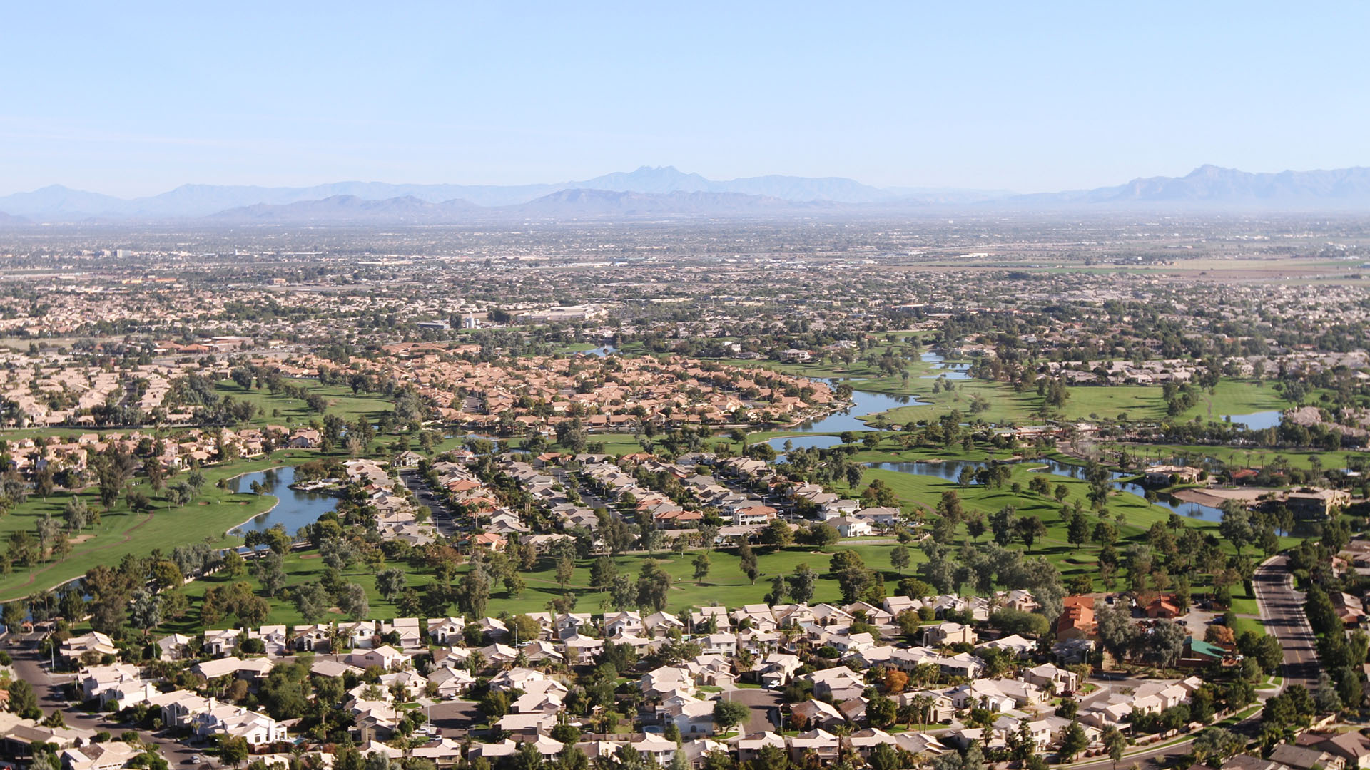 Aerial view of Chandler, Arizona in Maricopa County showing residential neighborhoods, golf courses, and desert landscape under clear skies