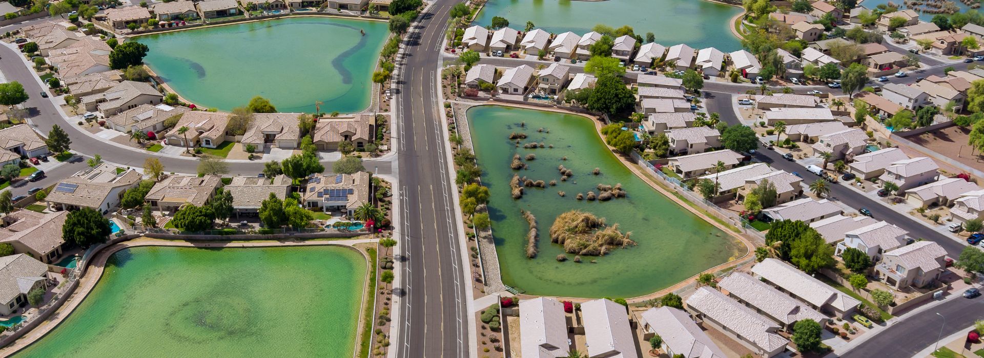 Aerial View of Alamar Community Neighborhood in Avondale, Arizona Aerial view of modern homes surrounding green lakes and rock islands in Alamar neighborhood, Avondale, Arizona – where massage therapists in Avondale, Arizona serve local residents