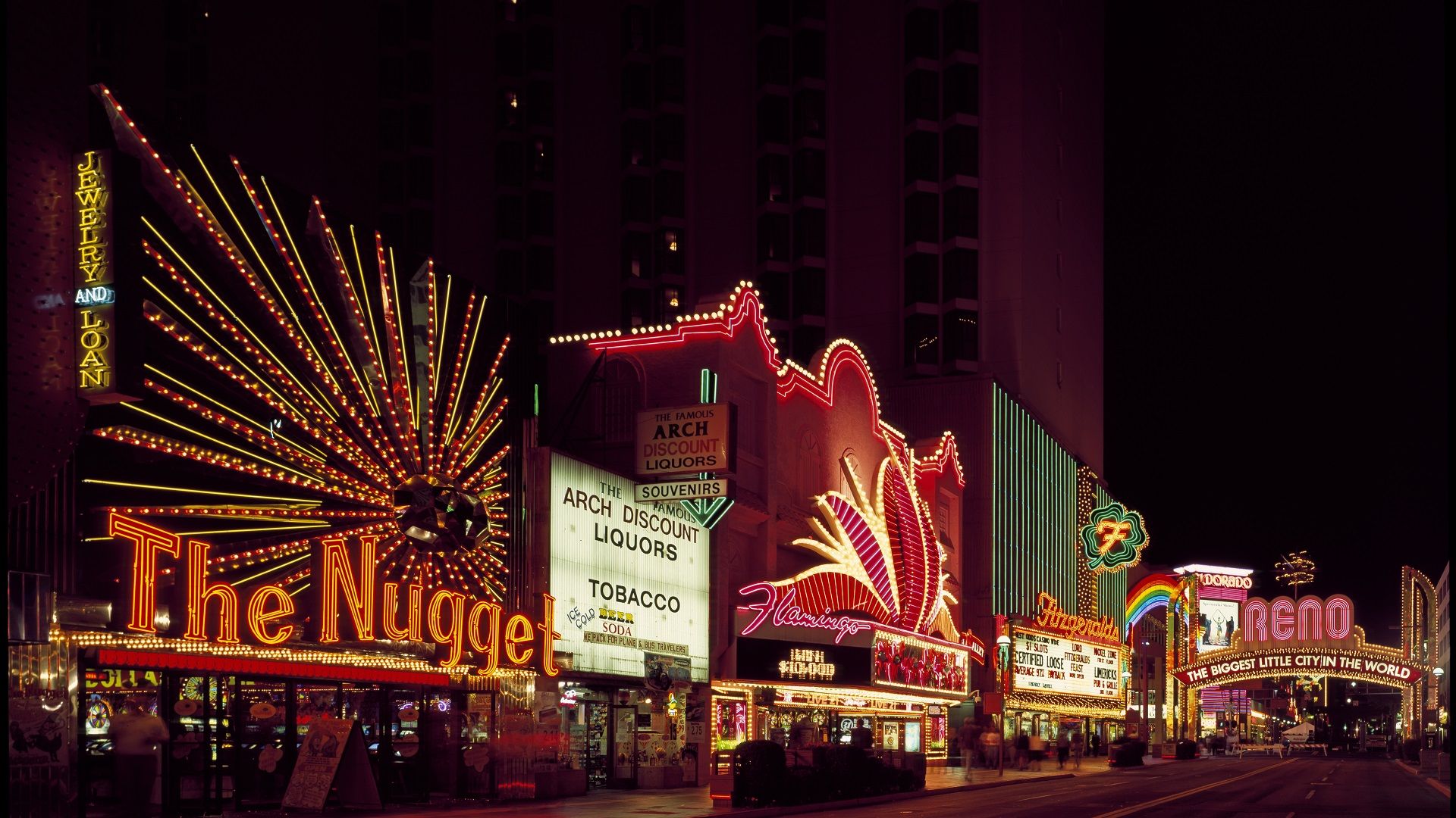 Night view of downtown Reno, Nevada, with the illuminated city arch and casinos, illustrating the vibrant setting served by local massage therapists.